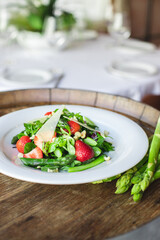 Healthy food, seasonal spring salad, green asparagus, arugula, fresh and healthy vegetables and fruits, herbs, homemade salad.
