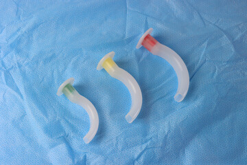 Different sizes of an Oropharyngeal airway above a surgical field 