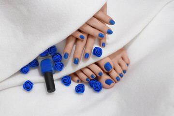 Woman showing her fingers and toes with blue nails. Blue nail polish and small blue artificial...