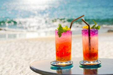 two colorful cocktails on the beach in summer