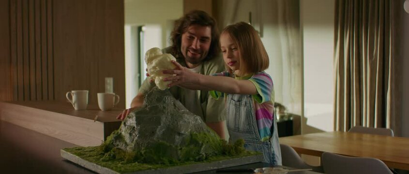 Portrait of father is helping his daughter to prepare a school science class volcano project, adding the eruption smoke made of foam Generative AI
