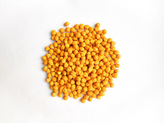 Heap of dry peeled chickpea or desi chickpea or desi Bengal gram or kala chana isolated on white background.Dry yellowish chickpea without husk.Pile of peeled bengal gram, chickpeas.