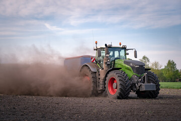 Trecker und Maislegemaschine verschwinden schon fast auf den Acker, so staubt es beim Maislegen. © Countrypixel