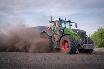 Trecker und Maislegemaschine verschwinden schon fast auf den Acker, so staubt es beim Maislegen.