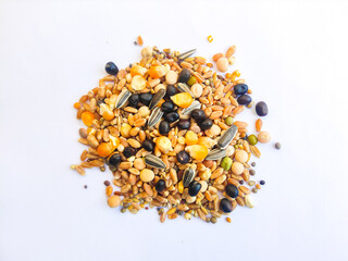 Pigeon food isolated on white background.A mix of wheat,corn,black pea,white pea,sunflower seeds,safflower, black mustard and other grains.Mixture of various kinds of grains,seeds for pigeon nutrition