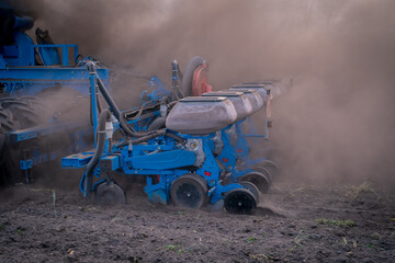 Saatgutbehälter der Drillmaschine verschwindet beim Maislegen im Staub.