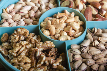 Mix of nuts in a container on a wooden table