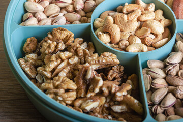 Mix of nuts in a container on a wooden table
