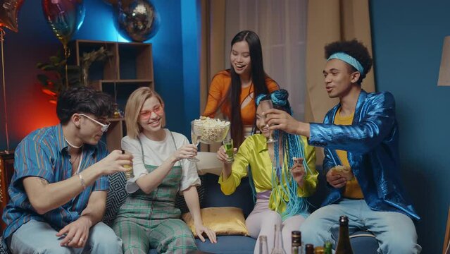 Group of friends making party at home in the living room. Multiethnic group of young people having fun in the apartment. Concept about friendship and lifestyle