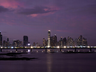 Fototapeta na wymiar Beautiful purple colored sky above the illuminated modern city district at dawn