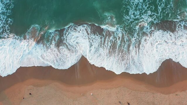 Drone view of beautiful seamless footage while turquiose sea waves breaking on sandy coastline. Aerial shot of golden beach meeting deep blue ocean water and foamy waves Generative AI