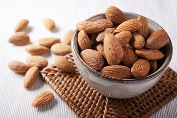 Shelled almonds in ceramic bowl, selective focus, closeup.