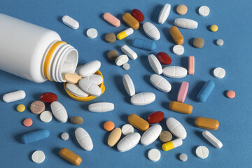Many medical pills of different colors and shapes scattered, close-up