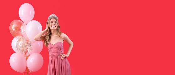 Beautiful young girl in prom dress and with balloons on red background with space for text
