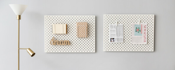 Hanging pegboards on grey wall and standard lamp in living room