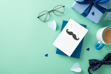 Trendy Father's Day theme. Flat lay top view of postcard with mustaches, giftbox with ribbon, bow-tie, accessories, paper hearts, spectacles, coffee cup on teal background with empty space for text