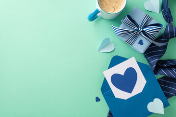 Trendsetting Father's Day design. Overhead shot of envelope with postcard, present box, coffee cup, and accessories on a turquoise backdrop with an empty space for text