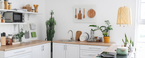 Light kitchen interior with modern furniture and pegboards