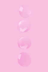 round drops of transparent gel serum on a pink background. gel with bubbles. Water droplets