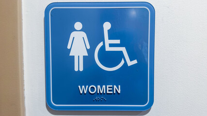 Restroom sign with figures of a girl, guy, and handicap symbol depicts gender and accessibility. The girl and guy figures indicate separate restrooms for men and women