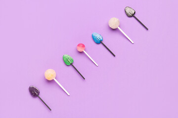 Composition with sweet lollipops on purple background