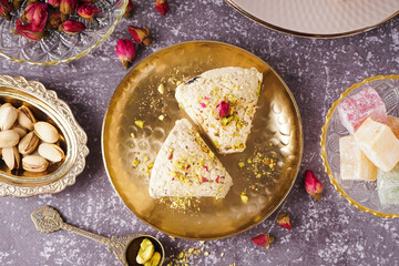 Plate with pieces of tasty Tahini halva on grunge background