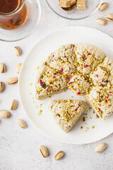 Plate of tasty Tahini halva with pistachios on light background