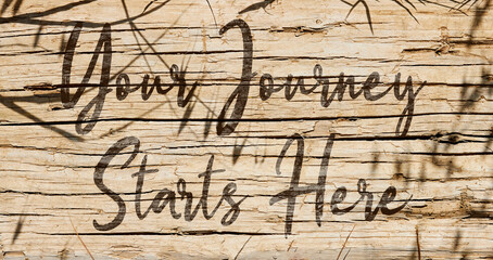 Your Journey Starts Here Concept on wooden background