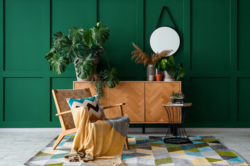 Interior of living room with armchair and Monstera houseplant