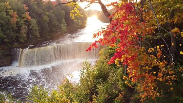 tahquamenon falls river waterfall in autumn and fall with bright red and yellow orange colors sunset sunrise, drone aerial shot and view drone
