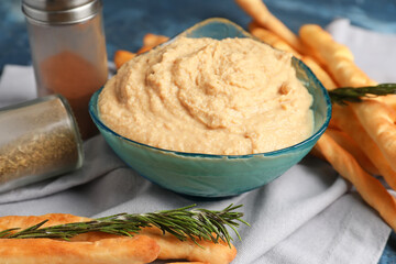 Bowl with tasty hummus on table, closeup