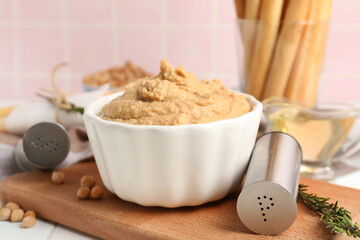 Bowl with tasty hummus on table, closeup