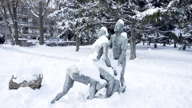 Statue of human with covered snow, people playing statue
