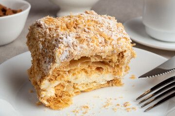 A piece of Napoleon cake on a plate. Sweet delicious dessert of puff pastry with custard.
