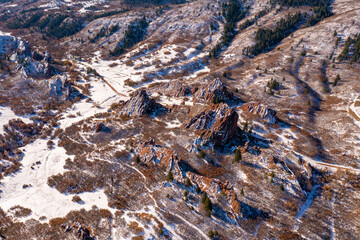 epic wide shot of red rock peaks sprinkled with snow in utah or colorado with a hill landscape during the day