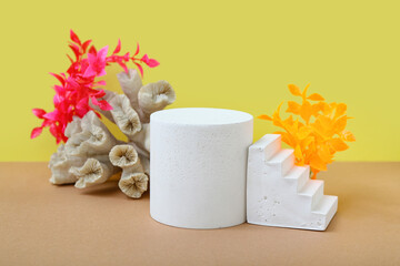 Decorative plaster podiums, coral and seaweed on yellow background