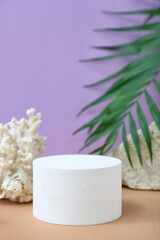 Obraz na płótnie Canvas Decorative plaster podium, stones, coral and palm leaves on purple background