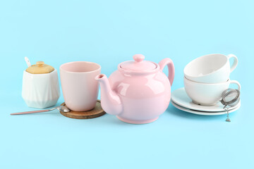 Stylish tea set on blue background