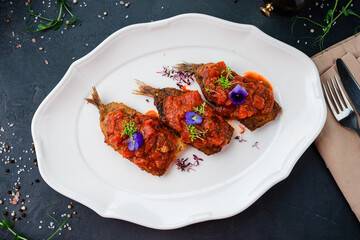 Fried fish with tomato sauce and herbs.