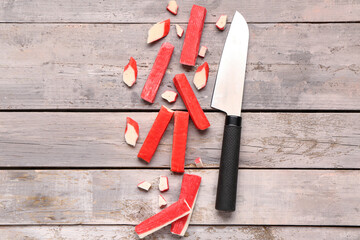Tasty cut and whole crab sticks on light wooden background © Pixel-Shot