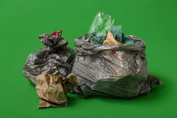 Full trash bags on green background