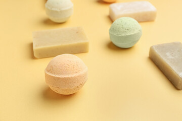 Bath bombs with soap bars on yellow background, closeup