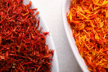 Bowls with pile of saffron on white background, closeup