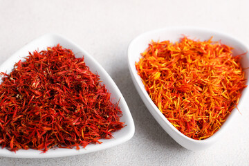 Bowls with pile of saffron on white background