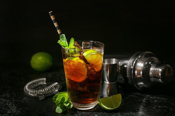 Glass of tasty Cuba Libre cocktail on dark background