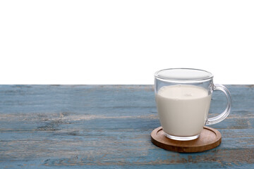 Cup of milk on blue wooden table against white background