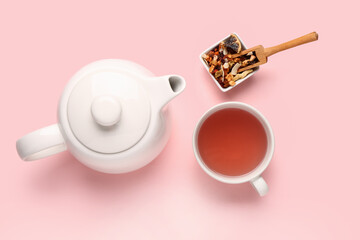 Ceramic teapot with cup of tea on pink background