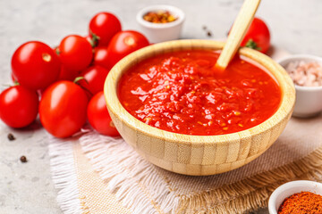 Bowl with tasty tomato sauce on table, closeup