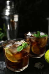 Glasses of cold Cuba Libre cocktail on dark background