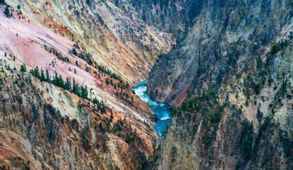 Blue waters of Yellowstone river flowing through colorful canyon. Yellowstone National Park, Wyoming, United States.